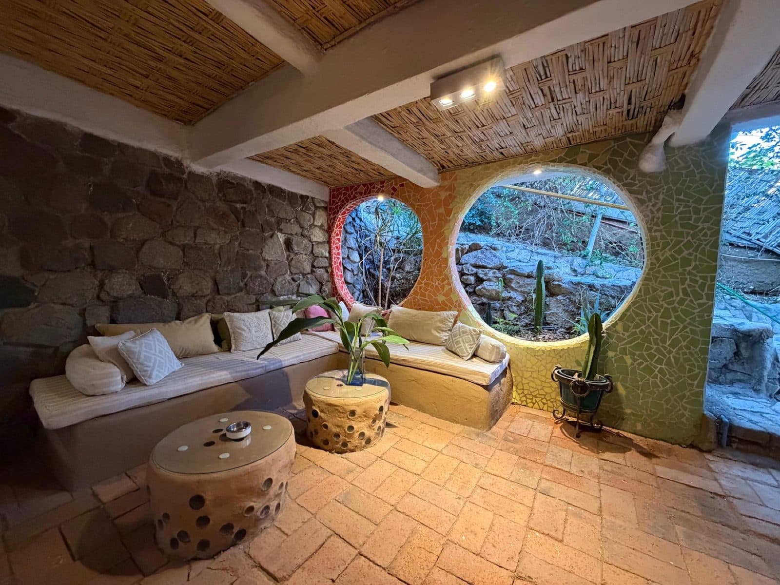 Living con muro de piedra y ventanas redondas
