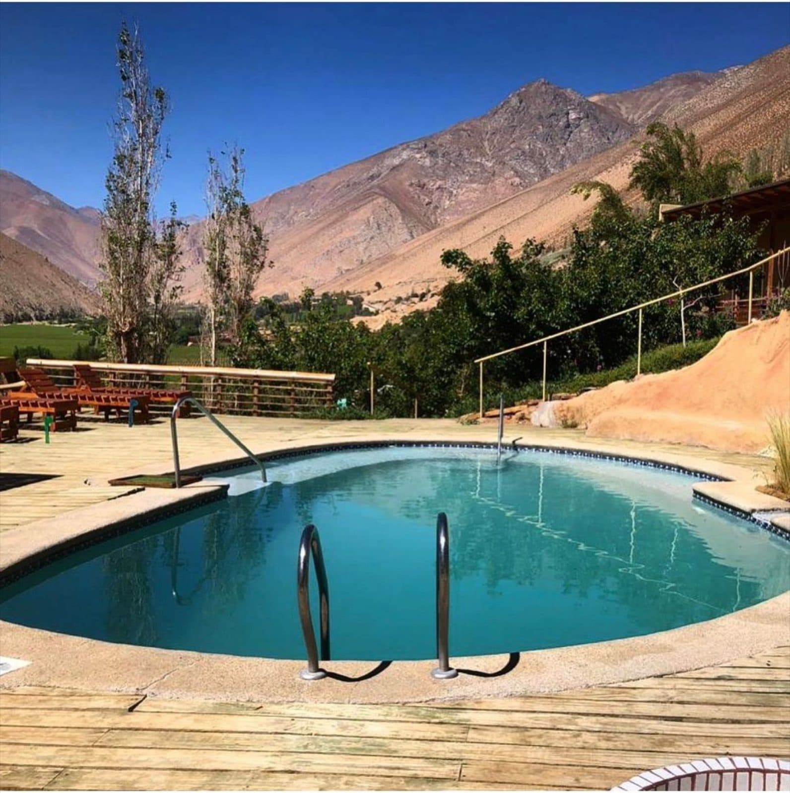 Piscina rodeada de árboles y cerros