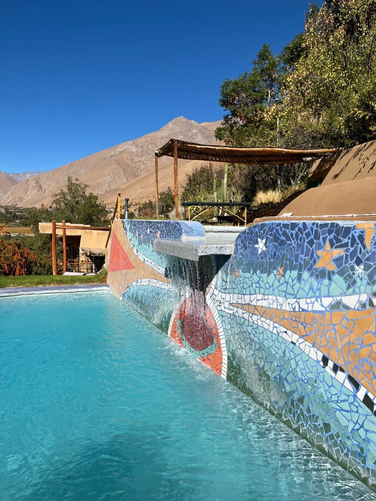 Piscina con mosaico y cerros al fondo