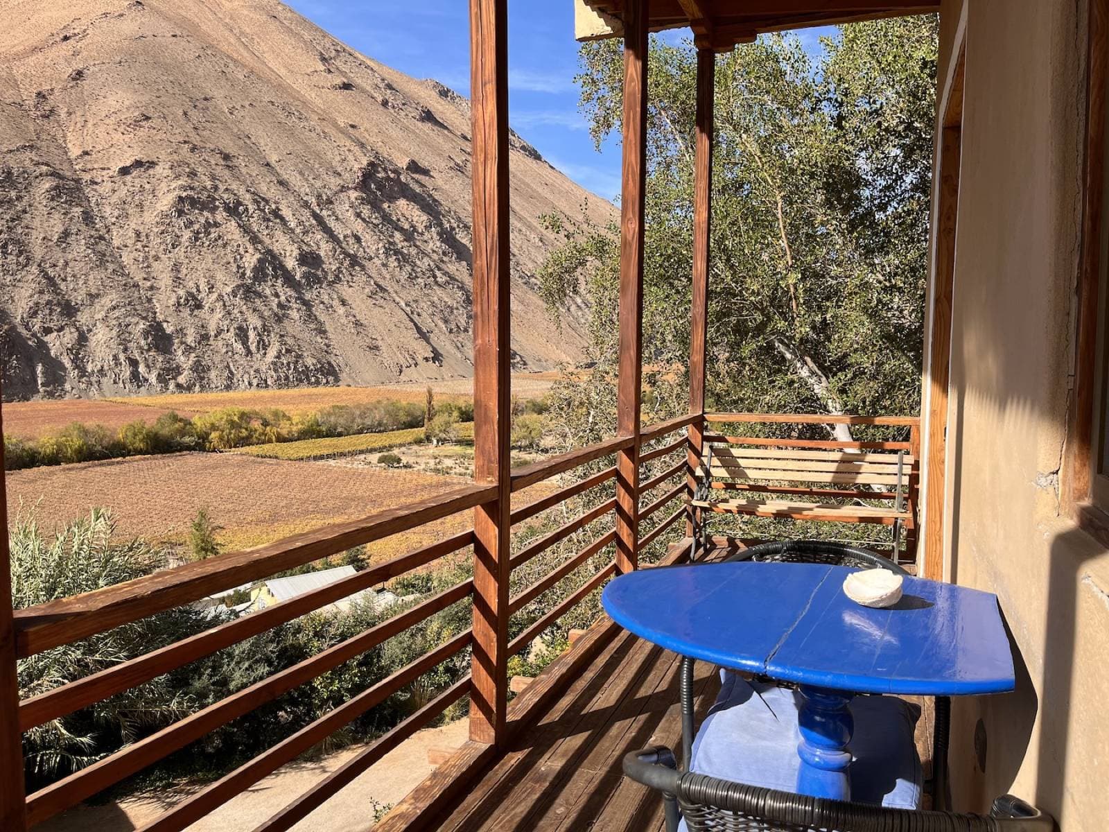 Terraza con mesa azul y vista al valle