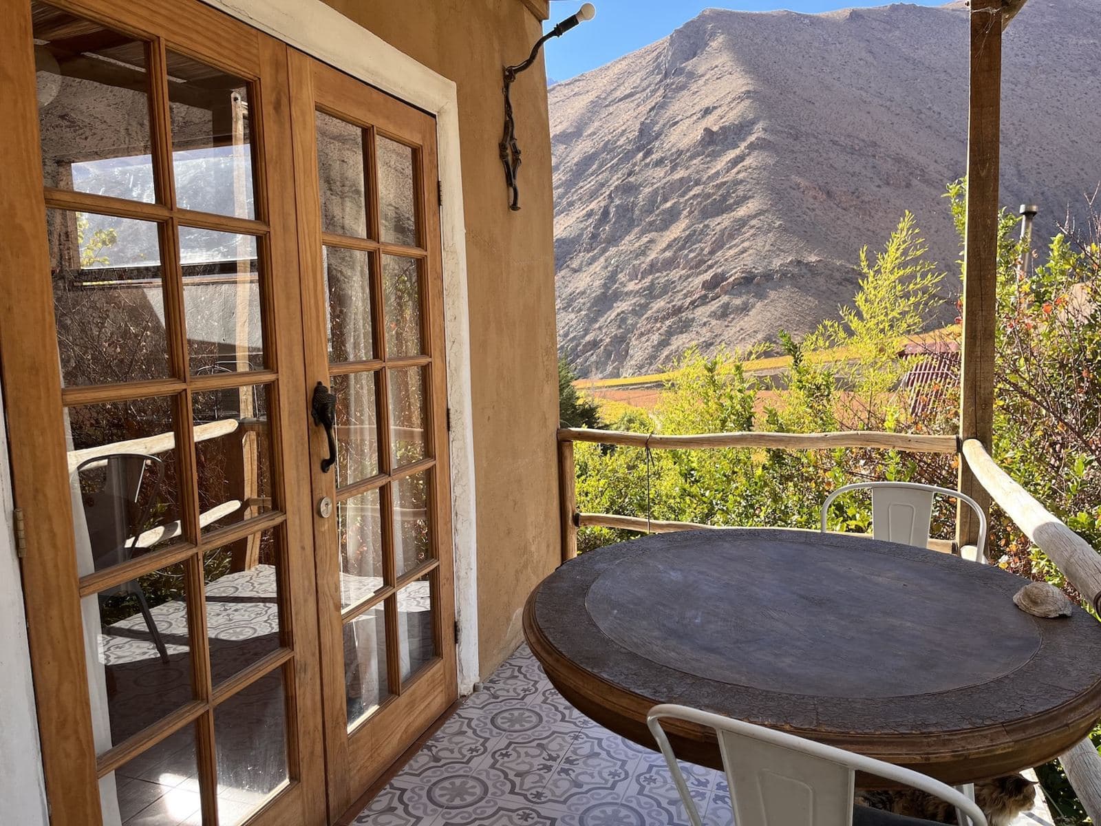 Terraza de cabaña con mesa y vista al cerro