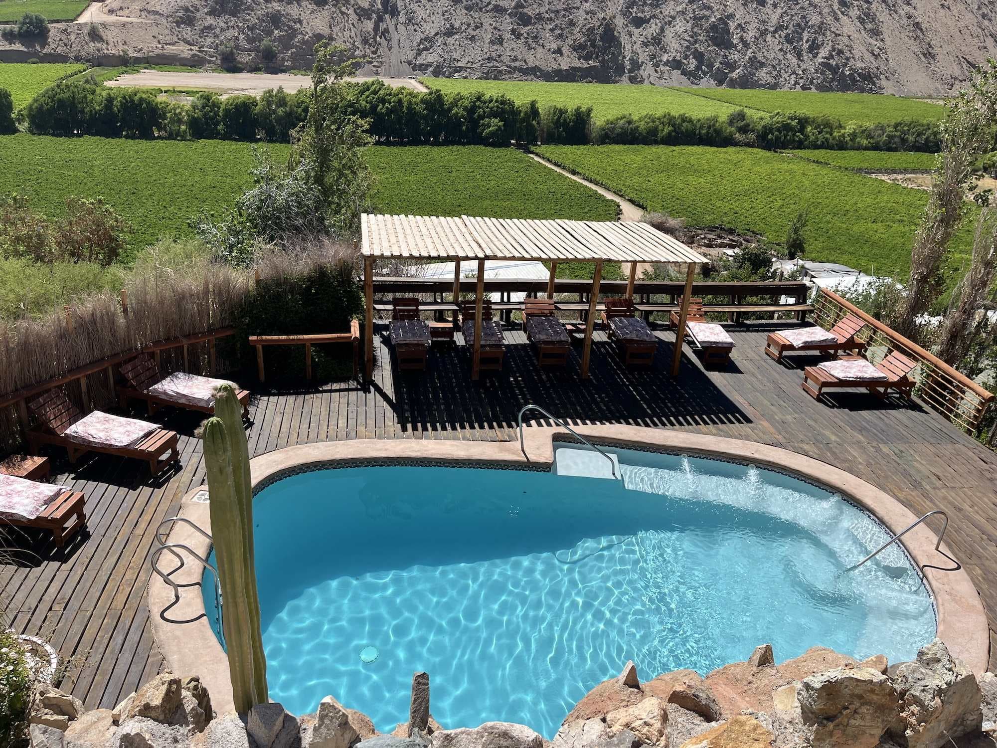 Piscina de agua salada de Cabañas Elquimista con el Valle del Elqui y sus cerros al fondo